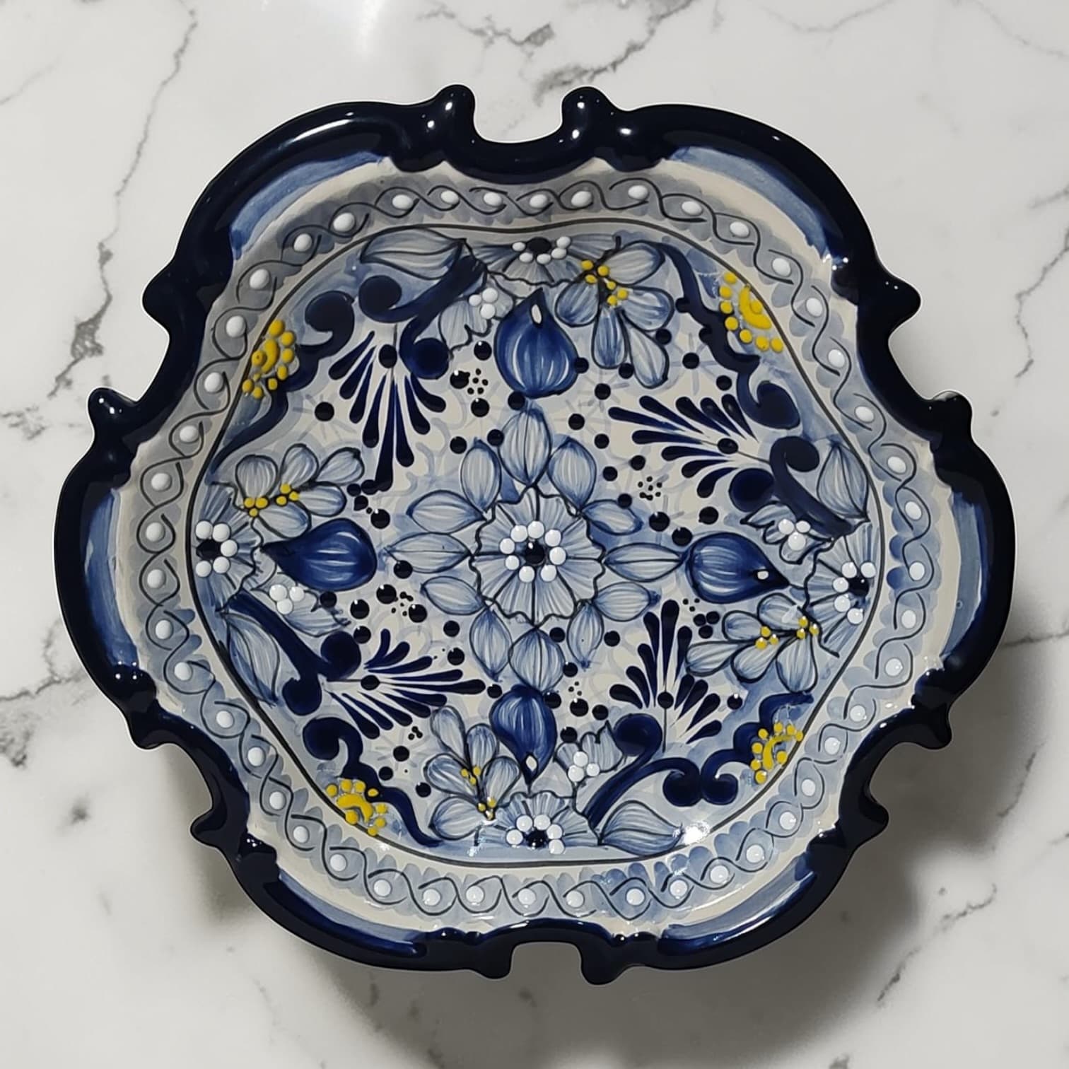 Plato barroco de Talavera con motivos florales en azul y oro
